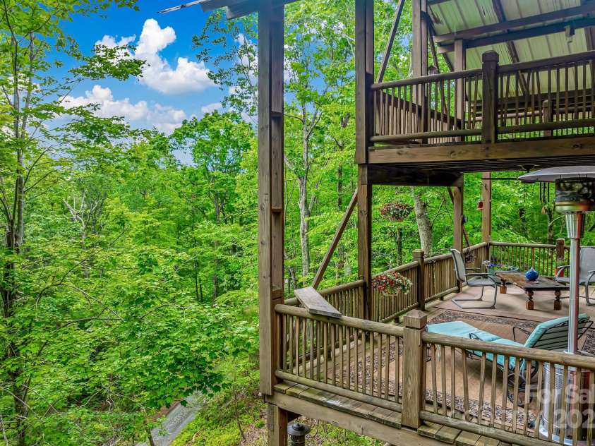 214 Laurel Mountain Trail, Saluda, NC 28773.  MLS# CAR4259688, YatesRealty ID 18449. The top level deck is even more protected under the metal roof.  Enjoy the sounds of rain without getting wet.