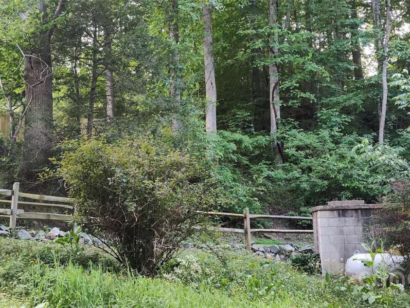 7881 US 25/70 Highway, Marshall, NC 28753.  MLS# CAR4257873, YatesRealty ID 18474. Split rail fencing borders the driveway entry