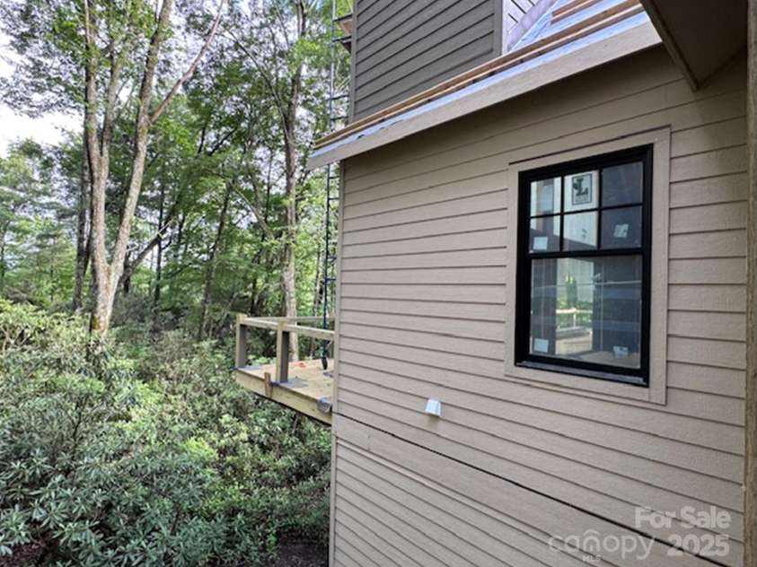 88 Lost Trail, Highlands, NC 28741.  MLS# CAR4260477, YatesRealty ID 18487. Corner of the Back Deck and Woods