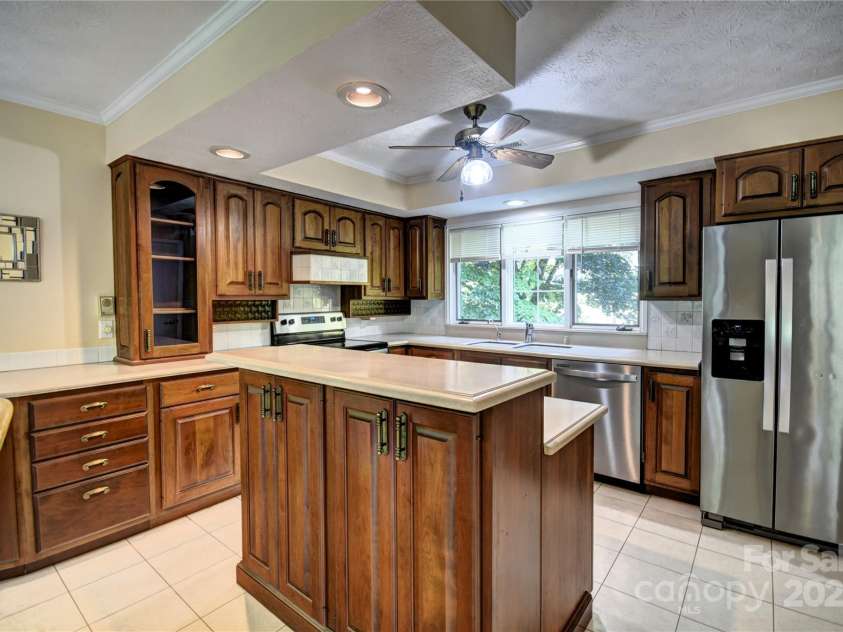 41 Balsam Shadows Road, Maggie Valley, NC 28751.  MLS# CAR4266877, YatesRealty ID 18489. Kitchen with island bar, SS appliances and Corian countertops