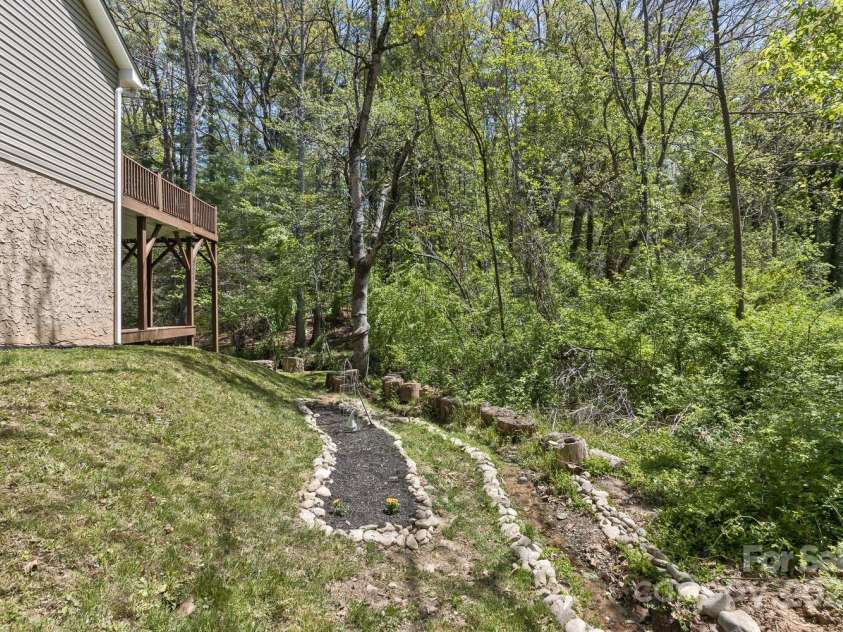 689 New Haw Creek Road, Asheville, NC 28805.  MLS# CAR4251121, YatesRealty ID 18491. Side yard with creek and gardening area