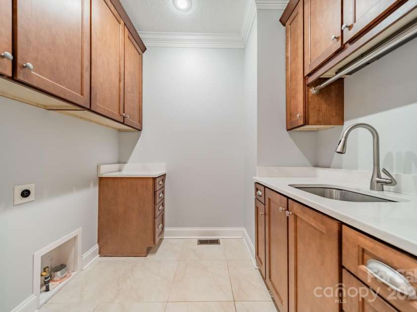 165 Blue Ridge Trail, Mooresville, NC 28117.  MLS# CAR4225294, YatesRealty ID 18540. Large first floor laundry room with a sink, lots of storage and new quartz counters.