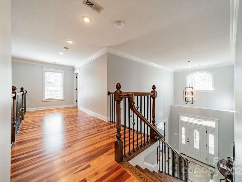 165 Blue Ridge Trail, Mooresville, NC 28117.  MLS# CAR4225294, YatesRealty ID 18540. Upstairs landing toward the first ensuite bedroom with the 2 story foyer below.