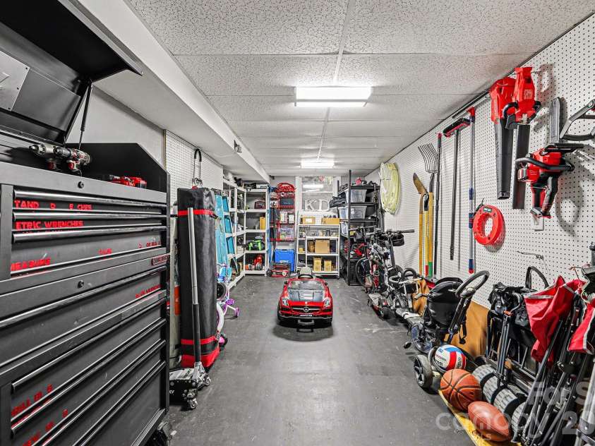 123 Old Bell Road, Charlotte, NC 28270.  MLS# CAR4333657, YatesRealty ID 18610. Heated & air conditioned workshop behind the 2-car tadem garage.  (Vent is behind the peg board where the shovel is on the right.)