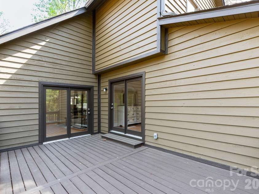 68 Sigmon Road, Fletcher, NC 28732.  MLS# CAR4336800, YatesRealty ID 18650. Back deck with elevated views of the wooded surroundings—perfect for entertaining or unwinding in nature.