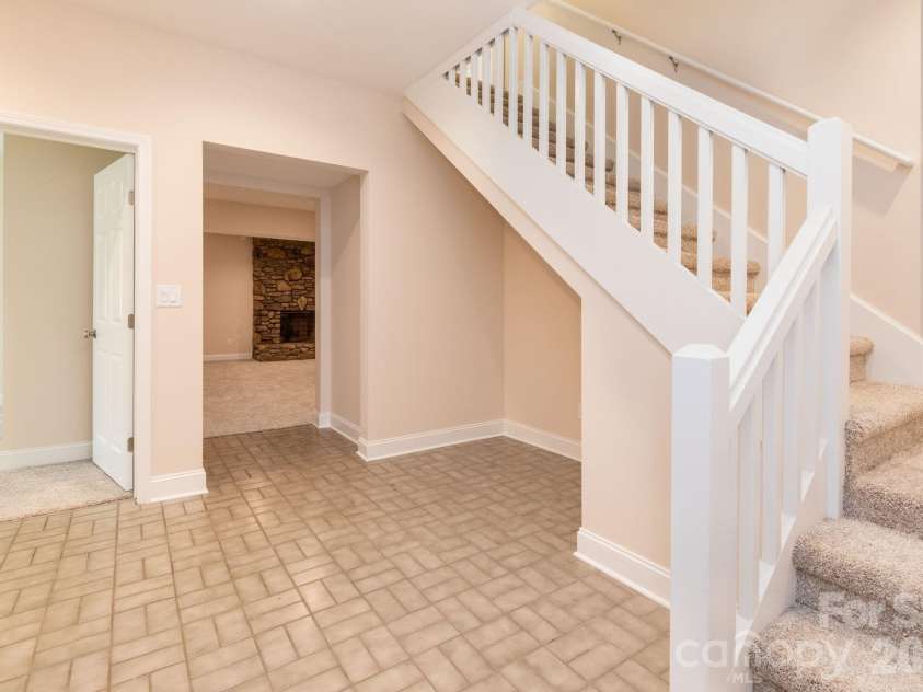 68 Sigmon Road, Fletcher, NC 28732.  MLS# CAR4336800, YatesRealty ID 18650. Lower-level entry and stairway access with durable tile flooring and easy flow to living areas—ideal for guests or multi-generational living.