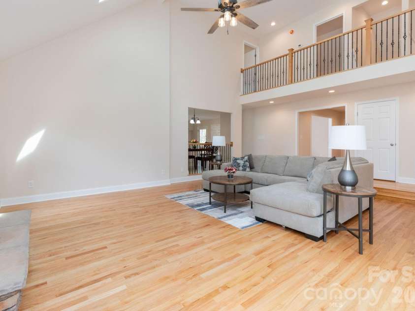 68 Sigmon Road, Fletcher, NC 28732.  MLS# CAR4336800, YatesRealty ID 18650. Open-concept living area with hardwood floors, loft overlook, and abundant natural light throughout.