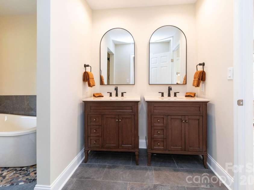 68 Sigmon Road, Fletcher, NC 28732.  MLS# CAR4336800, YatesRealty ID 18650. Primary bathroom featuring dual vanities with granite countertops and stylish fixtures.