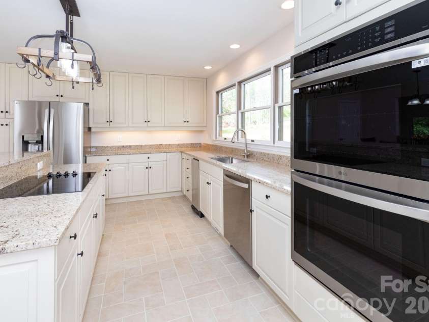 68 Sigmon Road, Fletcher, NC 28732.  MLS# CAR4336800, YatesRealty ID 18650. Spacious kitchen with center island, stainless steel appliances, and generous counter space for cooking and entertaining.