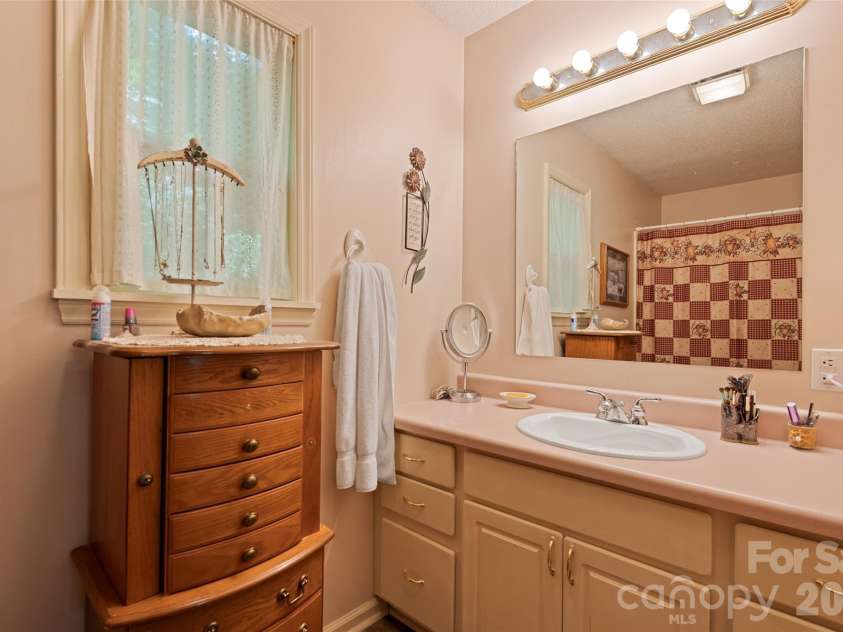 650 Creekside Drive, Maggie Valley, NC 28751.  MLS# CAR4335648, YatesRealty ID 18657. Dual sinks and stand up shower featured in the primary bathroom 