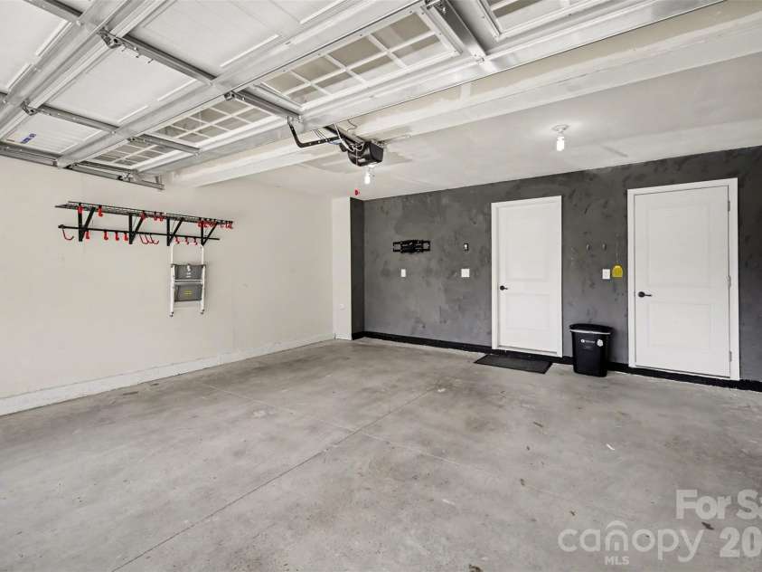 1211 May Apple Drive, Matthews, NC 28104.  MLS# CAR4349780, YatesRealty ID 18695. Spacious two-car garage featuring wall-mounted storage racks with interior access, and storage closet