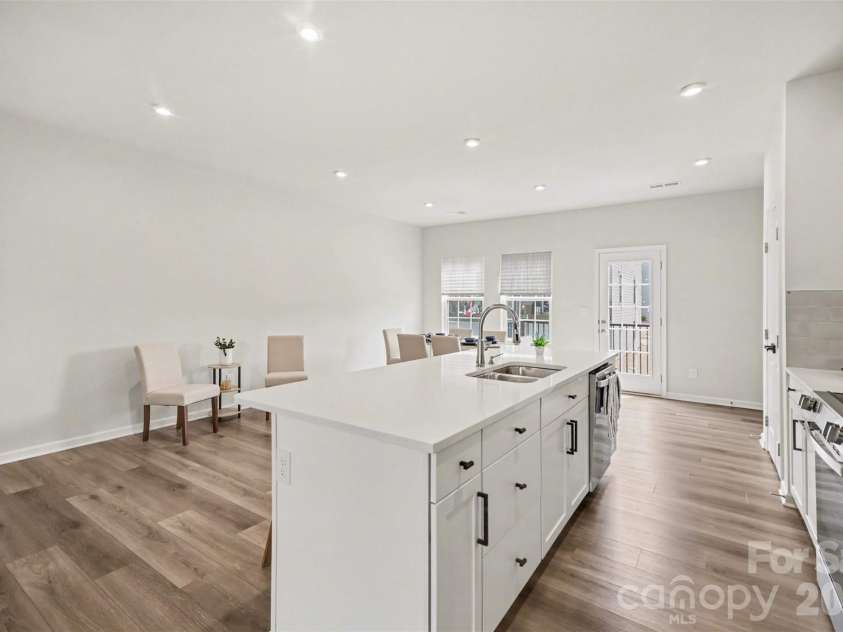 1211 May Apple Drive, Matthews, NC 28104.  MLS# CAR4349780, YatesRealty ID 18695. SS double bowl kitchen sink, dishwasher, & ample storage cabinetry space at the island.