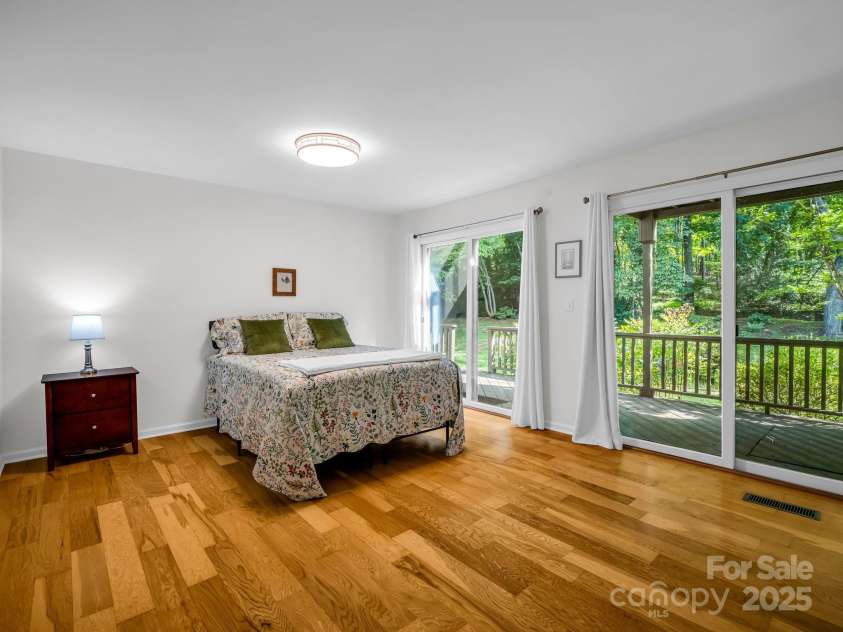 8 Hunting Country Trail, Tryon, NC 28782.  MLS# CAR4244551, YatesRealty ID 18739. Primary bedroom suite on the main level with access to a covered deck