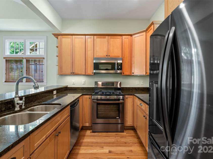 50 Mandolin Drive, Black Mountain, NC 28711.  MLS# CAR4264408, YatesRealty ID 18743. One of my favorite aspects of this home is that the kitchen is open to the dining and living room. Not only that, but the countertops are luxurious, there's a gas cooktop, a large double sink, and the convection ove