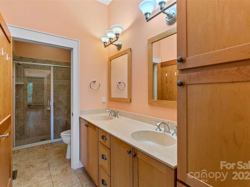 50 Mandolin Drive, Black Mountain, NC 28711.  MLS# CAR4264408, YatesRealty ID 18743. The master ensuite bathroom is equipped with a dual-sink vanity with cultured marble sinks and tile floors.