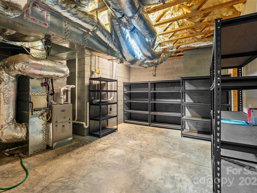 50 Mandolin Drive, Black Mountain, NC 28711.  MLS# CAR4264408, YatesRealty ID 18743. There is a brand new gas furnace that was just installed in June 2024 in the utility storage room right off the lower level bedroom.  It's a great space with plenty of room to store your family heirlooms and things 