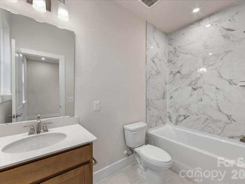 6008 Pivot Court, Charlotte, NC 28205.  MLS# CAR4396115, YatesRealty ID 18768. Secondary bathroom with tiled walls above the tub