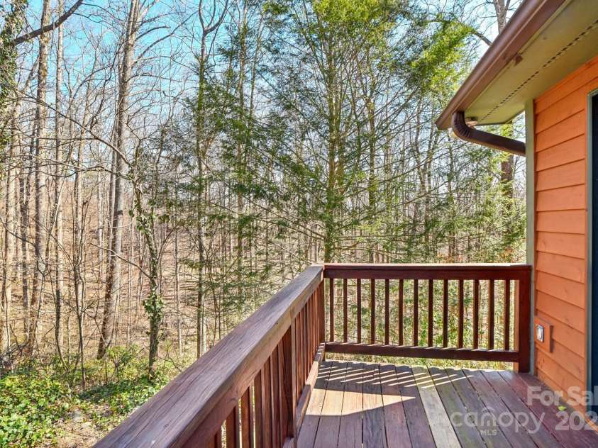 160 Lakota Lane, Tryon, NC 28782.  MLS# CAR4228822, YatesRealty ID 18789. Deck off the sun room overlooking private wooded lot