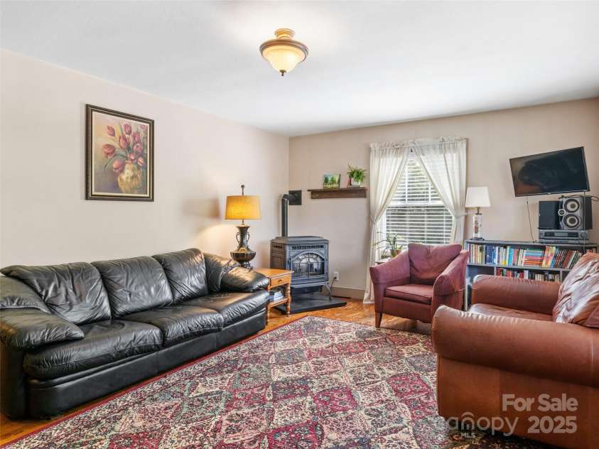 377 Cabin Road, Spruce Pine, NC 28777.  MLS# CAR4256421, YatesRealty ID 188. Living room with pellet stove