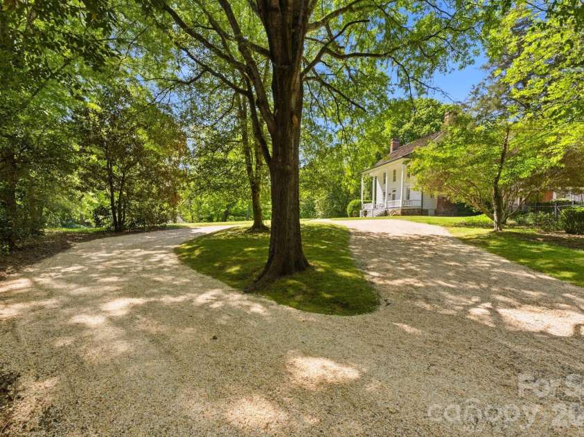 5520 Sharon View Road, Charlotte, NC 28226.  MLS# CAR4360655, YatesRealty ID 18805. Expansive private driveway surrounded by mature trees, offering a peaceful setting with ample parking and a sense of privacy