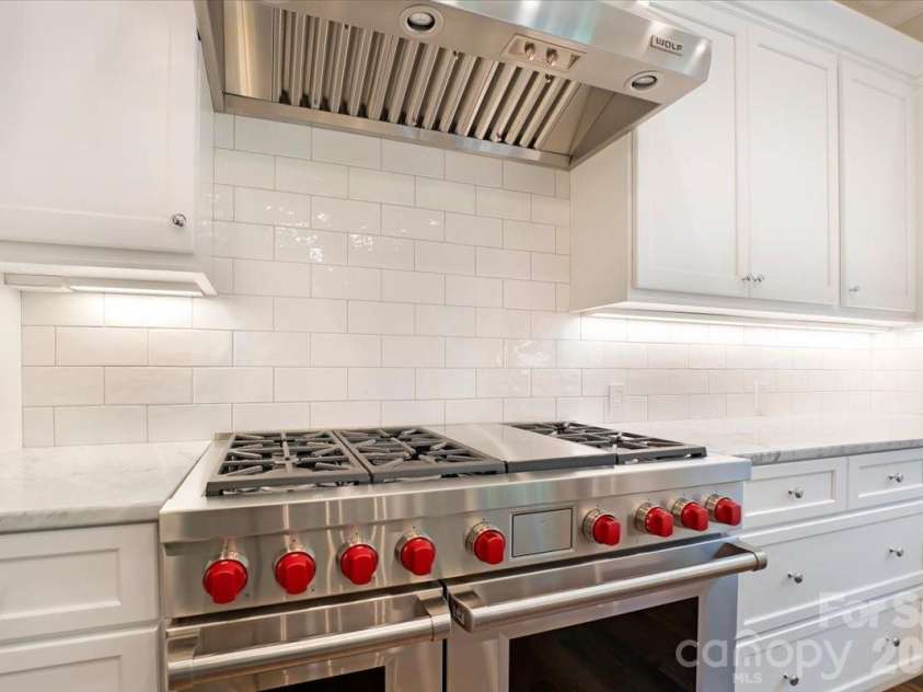 16728 Ashton Oaks Drive, Charlotte, NC 28278.  MLS# CAR4401853, YatesRealty ID 18814. Anchored by a professional-grade Wolf range, this beautifully appointed kitchen is designed to inspire everything from weeknight meals to memorable celebrations.