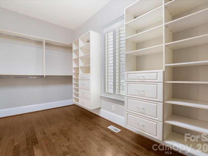 16728 Ashton Oaks Drive, Charlotte, NC 28278.  MLS# CAR4401853, YatesRealty ID 18814. The custom dressing room features extensive built-in storage, thoughtfully designed to keep everything beautifully organized and within reach.