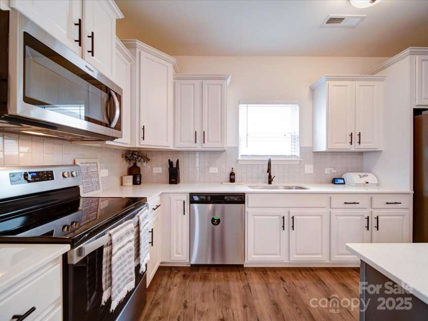 5121 Arbordale Way, Mount Holly, NC 28120.  MLS# CAR4269641, YatesRealty ID 18852. Another Kitchen View. Notice the beautiful White Cabinets with Solid Surface Counters & Stainless Appliances