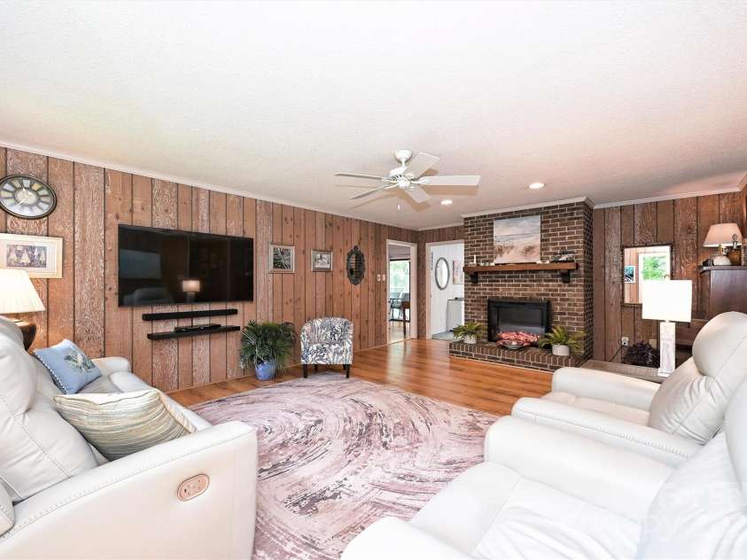 3017 Brooks Mill Lane, Wingate, NC 28174.  MLS# CAR4263524, YatesRealty ID 18864. Living room with electric fireplace and thick oak paneling