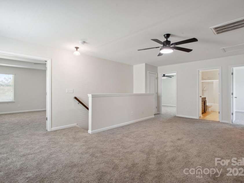 392 Winecoff Woods Drive, Concord, NC 28027.  MLS# CAR4259370, YatesRealty ID 18876. Loft showing Primary w/Doors to left