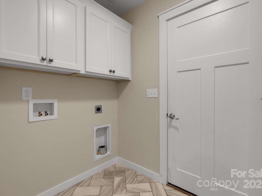 123 Dapple Road, Candler, NC 28715.  MLS# CAR4257282, YatesRealty ID 18892. The Laundry/Mudroom with herringbone tile and access from the garage