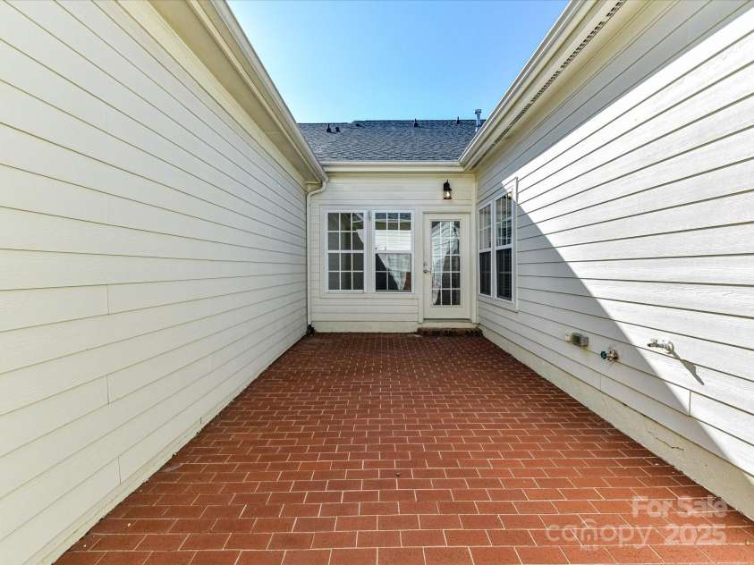 155 Harper Lee Street, Davidson, NC 28036.  MLS# CAR4328316, YatesRealty ID 18953. Private patio leading to the 2-car garage