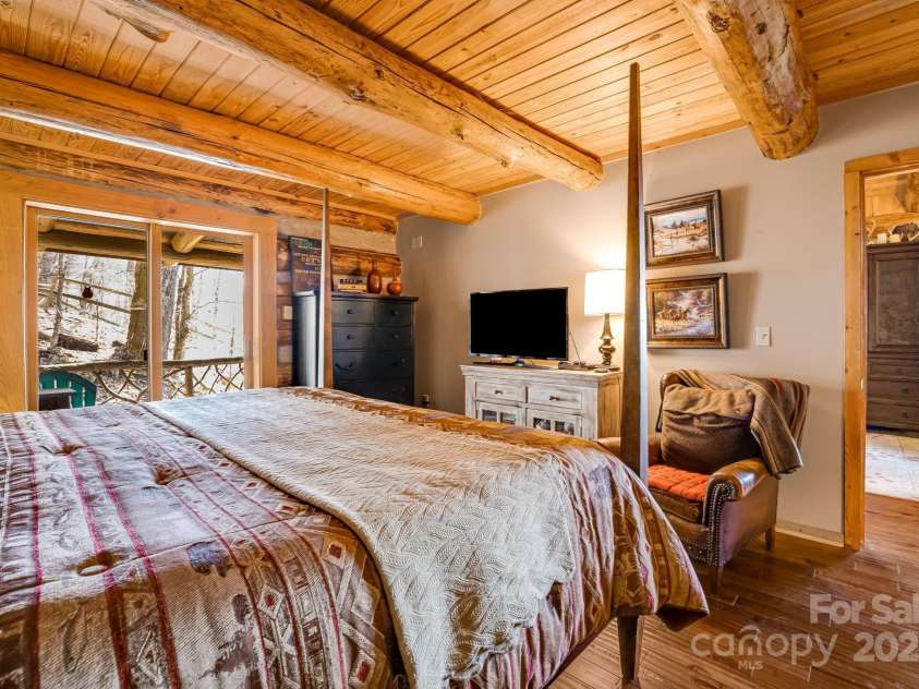 1873 El Miner Drive, Mars Hill, NC 28754.  MLS# CAR4251869, YatesRealty ID 18968. Main level primary bedroom with doors leading out onto the covered deck.