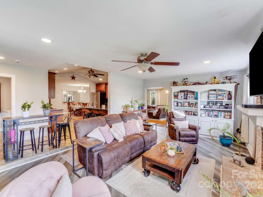 211 Drive Inn Road, Locust, NC 28097.  MLS# CAR4265447, YatesRealty ID 19009. Family room with mantel and brick fire place that leads into the kitchen offering space and functionality.