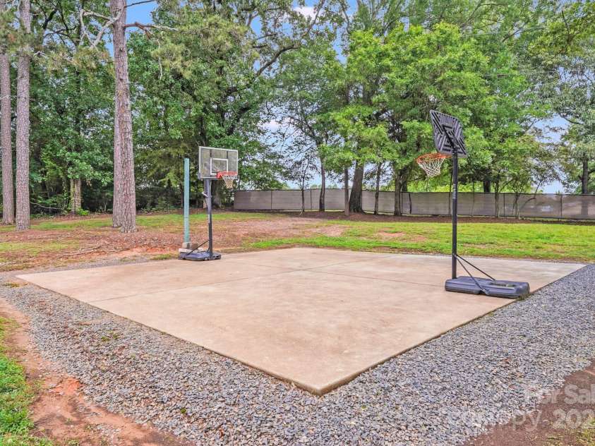 211 Drive Inn Road, Locust, NC 28097.  MLS# CAR4265447, YatesRealty ID 19009. Private Basket Ball Court located at the rear side yard of the property past the guest house.