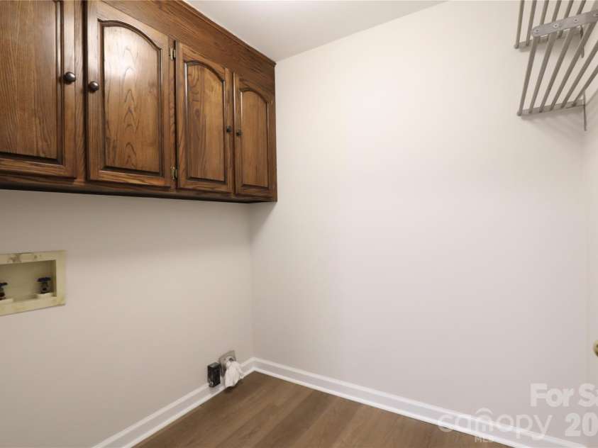 12809 Pine Bluff Road, Midland, NC 28107.  MLS# CAR4374117, YatesRealty ID 19012. Laundry with solid wood cabinets and new flooring.
