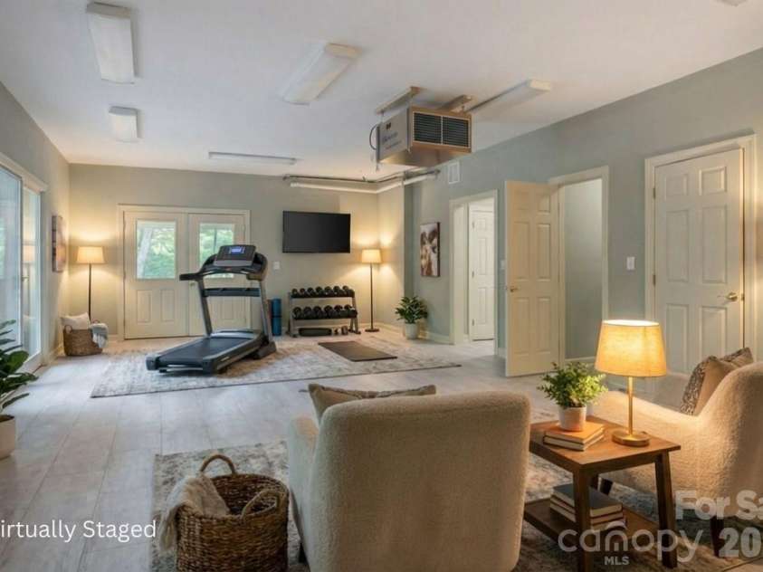 301 Gateway Drive, Hendersonville, NC 28739.  MLS# CAR4373962, YatesRealty ID 19050. Lower level flex room, virually staged as a gym and lounge.