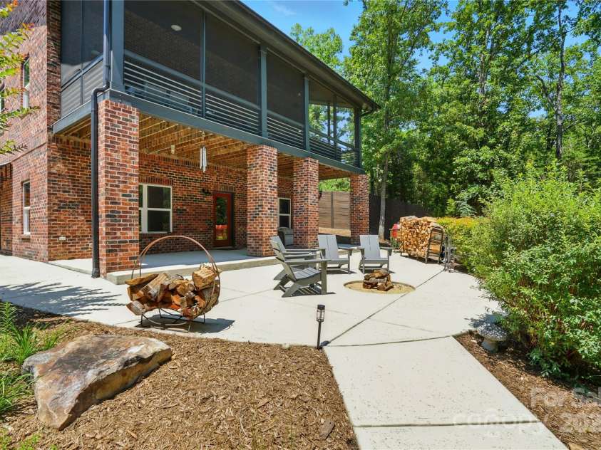 16525 Tulloch Road, Charlotte, NC 28278.  MLS# CAR4267483, YatesRealty ID 19120. Enjoy a covered patio, extended terrace with firepit, outdoor shower, and a gentle slope to the water’s edge with approximately 110 feet of shoreline