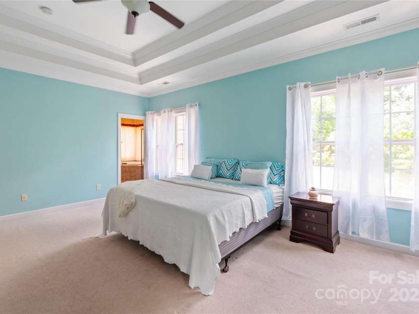 8914 Landsdowne Avenue, Harrisburg, NC 28075.  MLS# CAR4259422, YatesRealty ID 19156. Primary bedroom with double tray ceiling and crown molding.