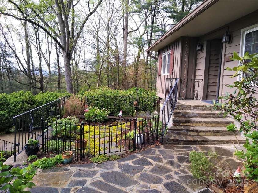 242 Birch Lane, Arden, NC 28704.  MLS# CAR4249293, YatesRealty ID 19164. Covered Entry with stone walkway and kitchen garden.