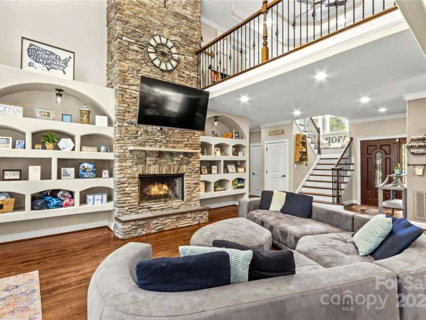141 Ridge Top Road, Mooresville, NC 28117.  MLS# CAR4255912, YatesRealty ID 19205. Two story great room is centered around a stacked stone, wood burning fireplace.