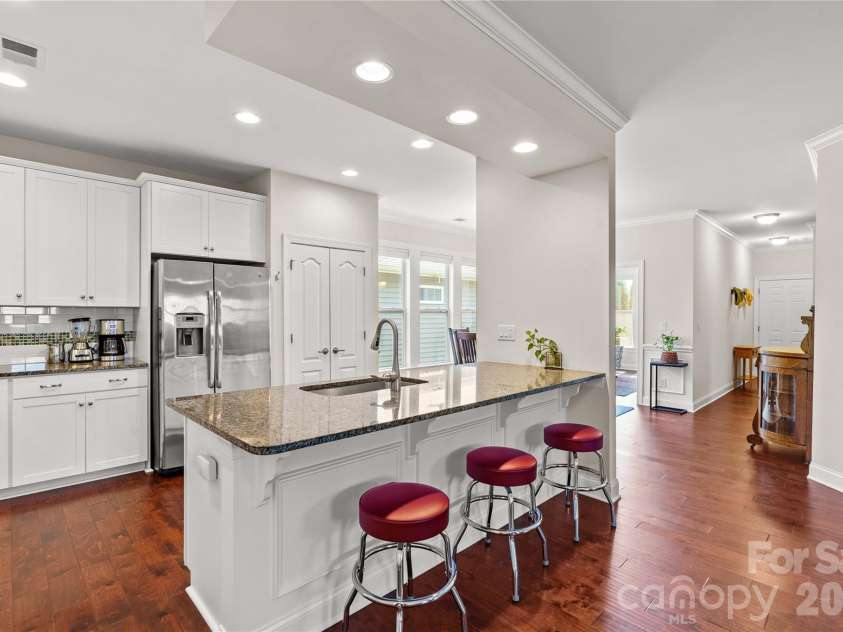 11528 Dublin Crescent Road, Cornelius, NC 28031.  MLS# CAR4364945, YatesRealty ID 19301. Upgraded kitchen includes a large center island, gas range, granite countertops, stainless appliances, and pantry with custom pullout draws.
