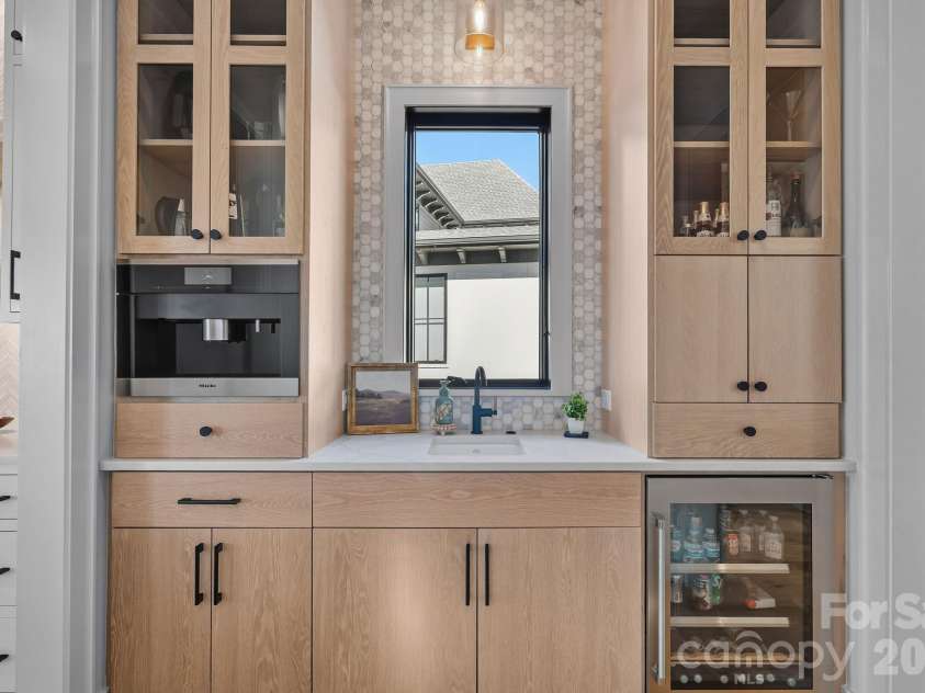 17811 Largo Place, Cornelius, NC 28031.  MLS# CAR4428601, YatesRealty ID 1945. Beautifully appointed beverage station with custom cabinetry, Miele coffee system, beverage refrigeration and a convenient prep sink.