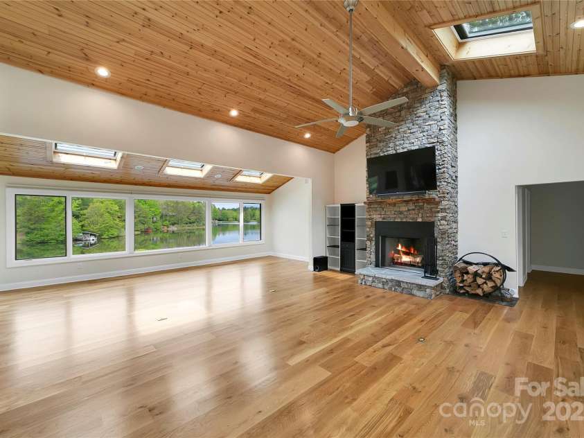 61 Tsataga Court, Brevard, NC 28712.  MLS# CAR4250347, YatesRealty ID 19462. Step into this inviting Great Room and Sunroom, where stunning lakefront views greet you at every turn.