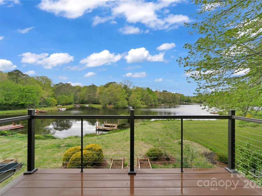61 Tsataga Court, Brevard, NC 28712.  MLS# CAR4250347, YatesRealty ID 19462. Step out onto the TimberTech deck from your primary bedroom balcony and take in the amazing, uninterrupted lake views a perfect spot for morning coffee or evening relaxation in your own private haven.