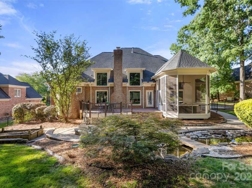 9219 Whispering Wind Drive, Charlotte, NC 28277.  MLS# CAR4261114, YatesRealty ID 19480. Rear yard has Screened porch, deck, paver patio, Koi pond with waterfall, fire pit, and a large planter box!