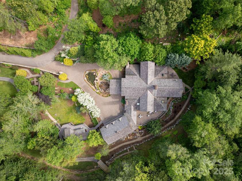 268 Holly Arbor Lane, Asheville, NC 28803.  MLS# CAR4268471, YatesRealty ID 19560. A beautiful 4-acre estate showcasing meticulously curated gardens, expansive outdoor living spaces, and charming cobblestone walkways.