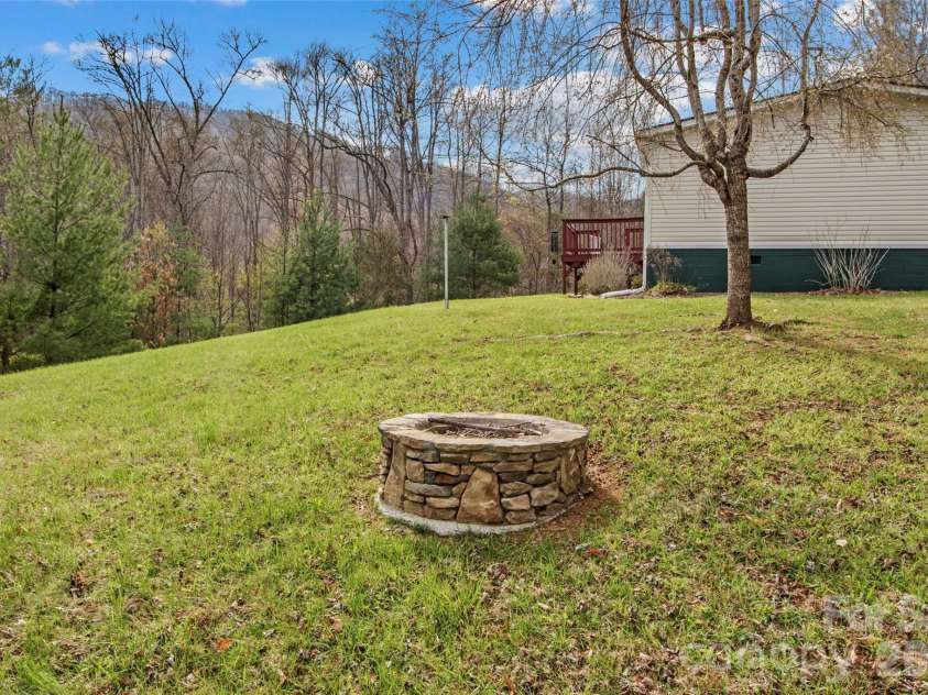 155 Thunderstruck Ridge, Burnsville, NC 28714.  MLS# CAR4365534, YatesRealty ID 19561. Side yard with fire pit