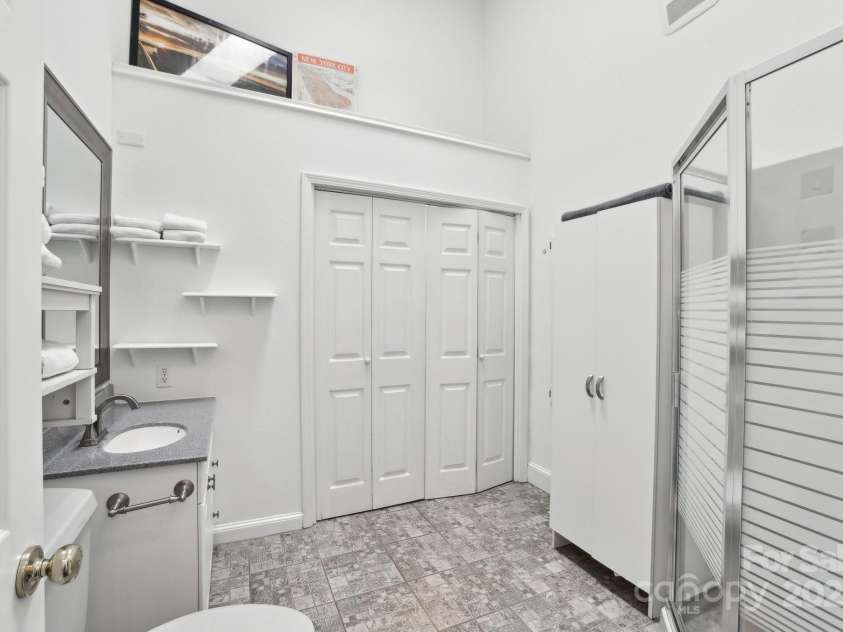 142 Justice Street, Fletcher, NC 28732.  MLS# CAR4234693, YatesRealty ID 19634. Gorgeous tile floors and convenient laundry closet in bathroom