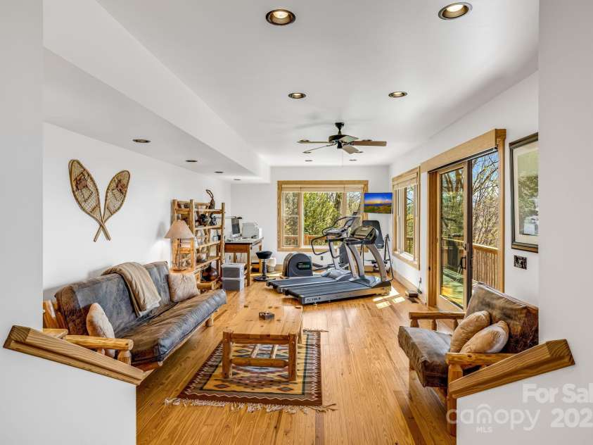 2399 El Miner Drive, Mars Hill, NC 28754.  MLS# CAR4259953, YatesRealty ID 19670. The fifth bedroom offers a versatile space with natural wood finishes, perfect for guests or family members seeking a private retreat. Bright windows invite in natural light, adding warmth to this cozy mountain escape.