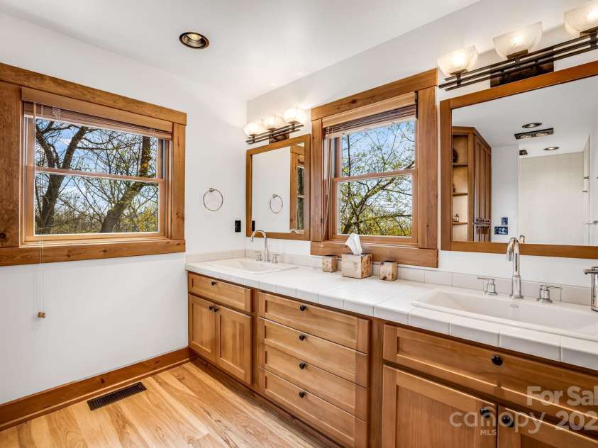 2399 El Miner Drive, Mars Hill, NC 28754.  MLS# CAR4259953, YatesRealty ID 19670. This beautifully designed bathroom features custom wood cabinetry with a thoughtful touch – an electrical plug hidden inside one of the deep drawers, perfect for keeping countertops clutter-free.